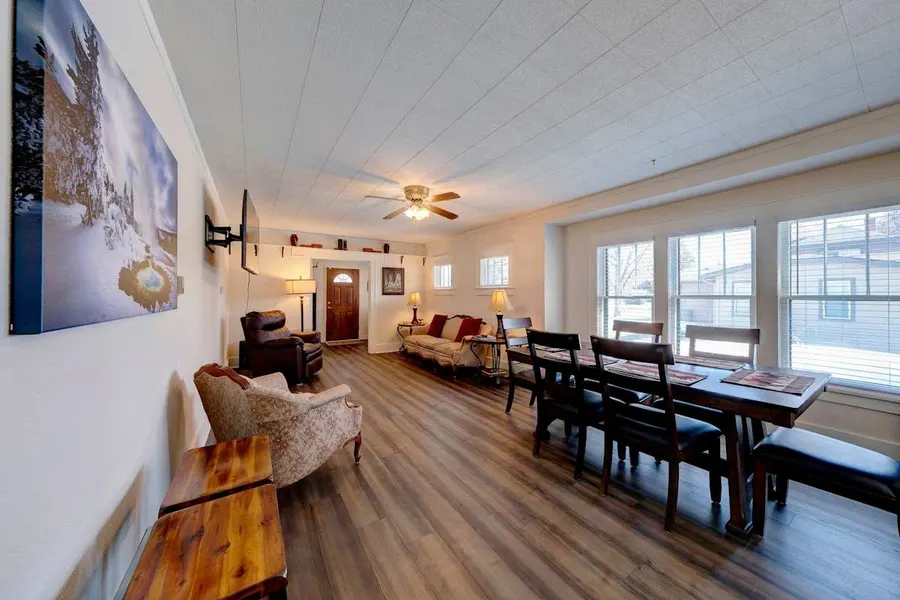 Long living and dining room with a wood dining table and tall front windows